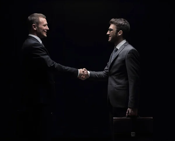 Dois empresários alegres apertando as mãos e olhando um para o outro — Fotografia de Stock