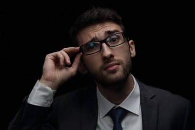 Siyah arka plan üzerine ekşitmeden genç duygusal iş adamı