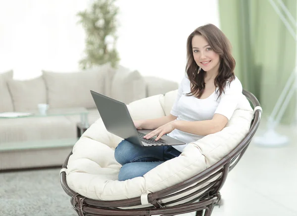 Beautiful young smiling woman working on laptop while sitting in — Stock Photo, Image
