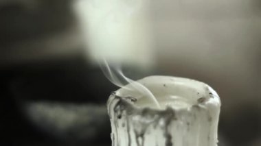 Koyu gri arka plan üzerinde beyaz mum sönmüş. Duman slowely