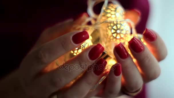Hands holding shiny Christmas lights with star shapes backward movement — Stock Video