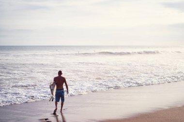  sörf tahtası tutan adam