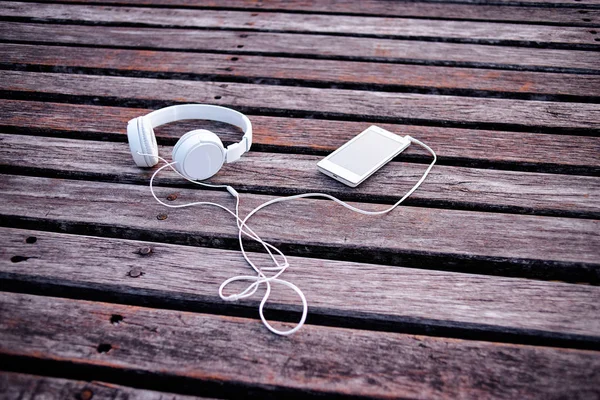 Bílá sluchátka a smartphone — Stock fotografie