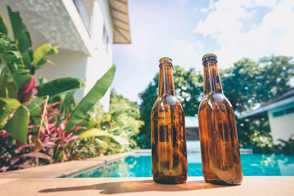 Bierflaschen in der Nähe von Schwimmbad. — Stockfoto