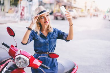 Smartphone kullanarak şapkalı genç kadın 