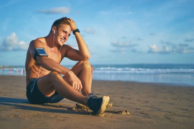 Adam sahilde oturan smartphone ile