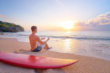 Sörf tahtası ile oturan adam