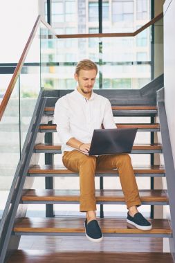 dizüstü bilgisayar üzerinde çalışan genç adam 