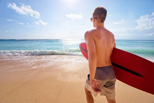 Giovane che tiene tavola da surf — Foto Stock