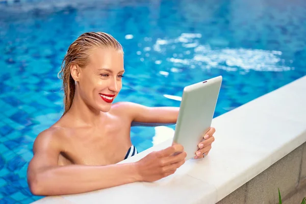 Femme utilisant une tablette dans la piscine — Photo