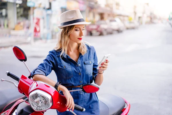 Ung kvinna i hatt med smartphone — Stockfoto