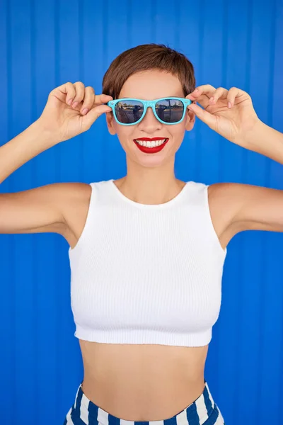 Mujer con maquillaje brillante sosteniendo gafas de sol — Foto de Stock
