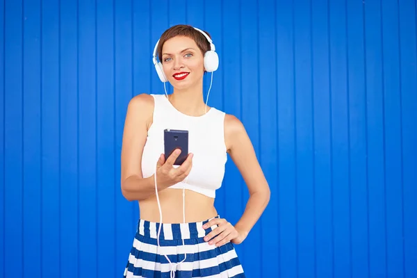 Jeune femme avec écouteurs blancs — Photo