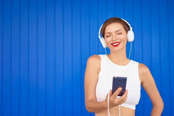 Jeune femme avec écouteurs blancs — Photo
