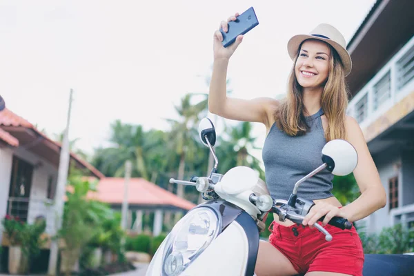 Женщина на скутере с помощью смартфона — стоковое фото