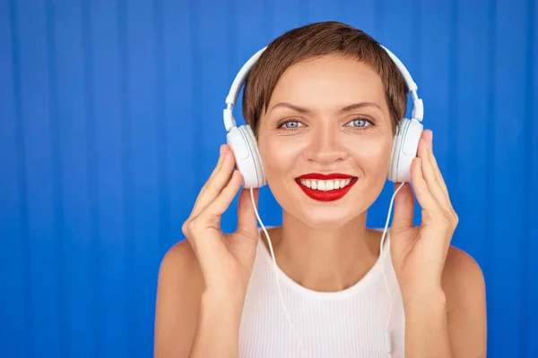 Νεαρή γυναίκα με λευκά ακουστικά — Φωτογραφία Αρχείου