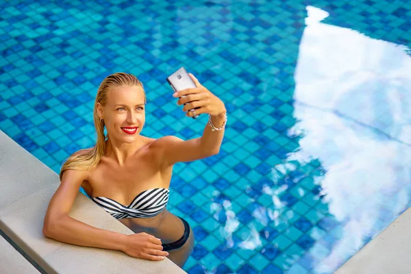 Mujer tomando selfie en piscina — Foto de Stock