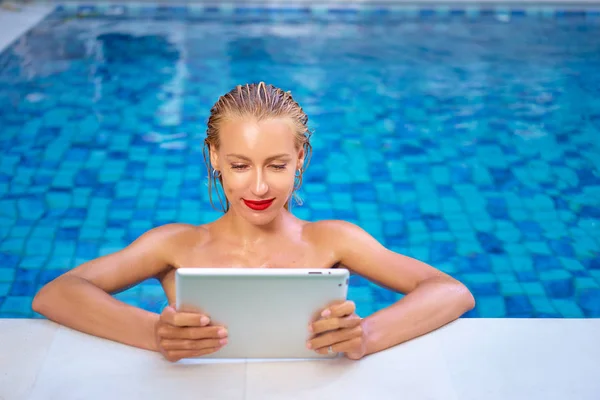 Femme utilisant une tablette dans la piscine — Photo