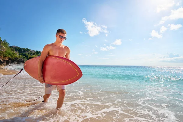 Ung man transporterar surfbräda — Stockfoto