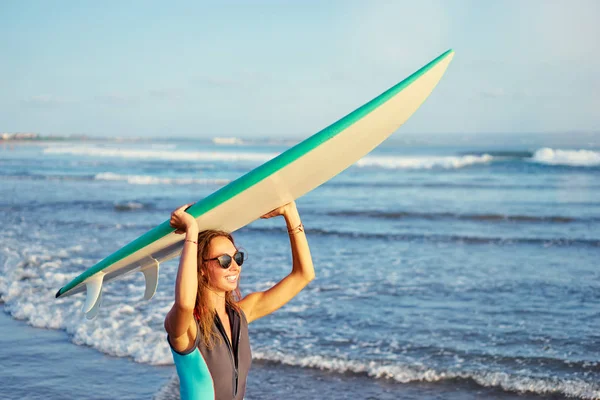 Young woman holding surf board