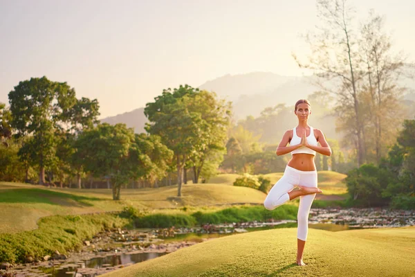 Young woman in asana pose — Stock Photo, Image