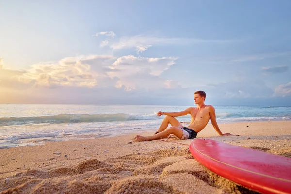 Hombre sentado con tabla de surf — Foto de Stock
