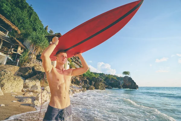 Joven llevando tabla de surf — Foto de Stock