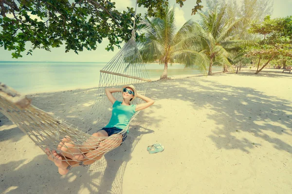 Woman in hat laying in hammock — Stock Photo, Image