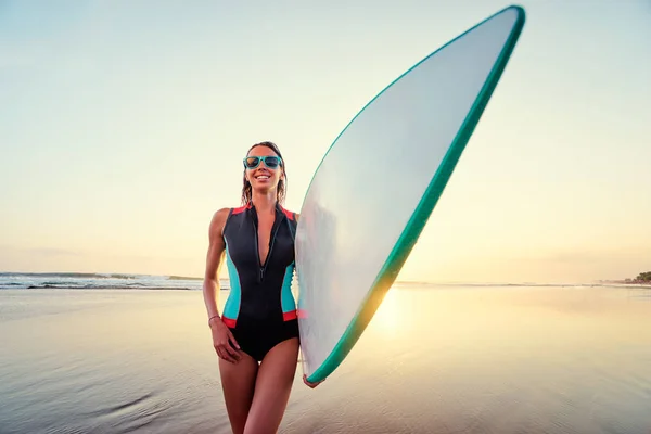 Young woman carrying surf board — Stock Photo, Image