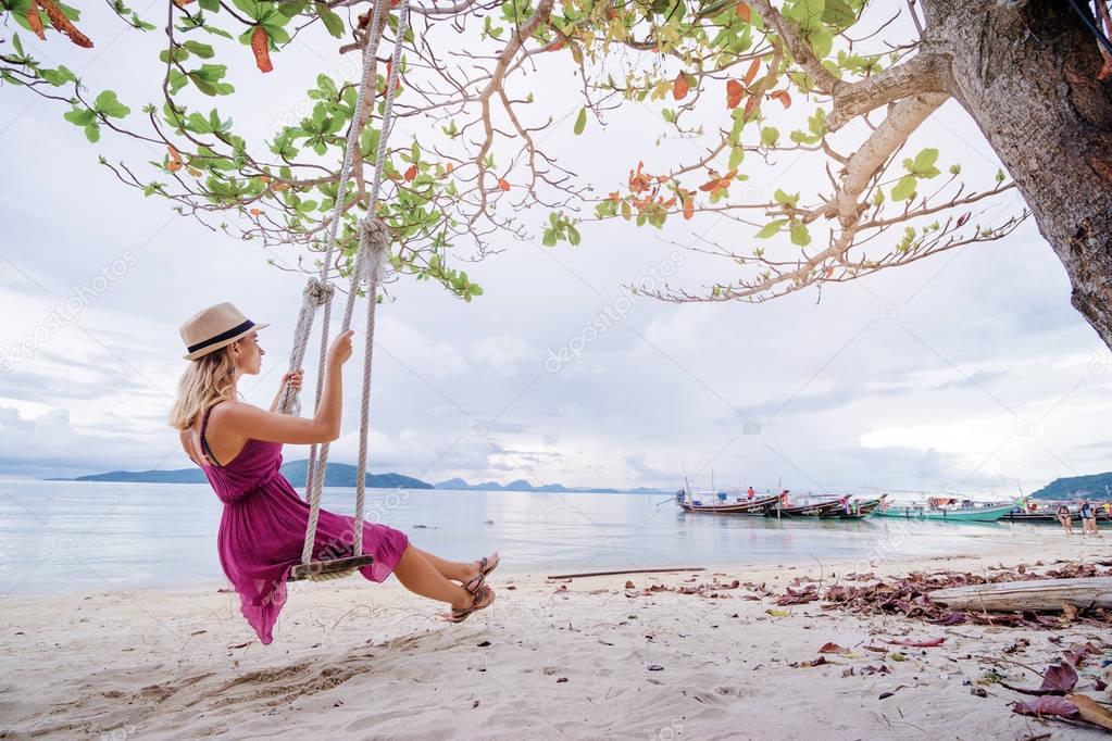 Woman swings on beach