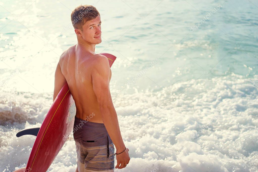Young man carrying surf board
