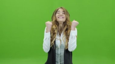 Genç bir kız bir yeşil Bouncing sevinir ve onu gürlemesi arka plan veya yeşil ekran eller sanki o kazandı