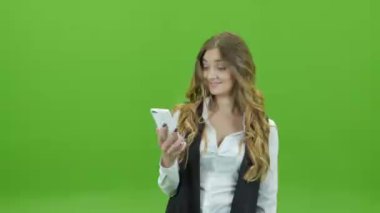 Bir telefon ile yeşil perde elinde bir yeşil zemin üzerine genç kız