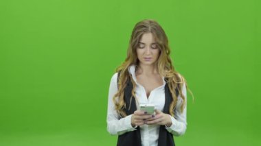Genç iş kadını manifatura telefon yeşil bir arka plan üzerinde
