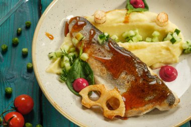 Patates püresi ve sebze püresi ile pişirilmiş levrek.