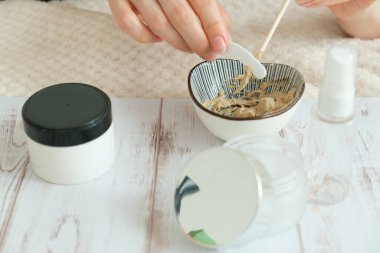 DIY kozmetik. Çerçevedeki eller farklı malzemelerden bir krema oluşturur..