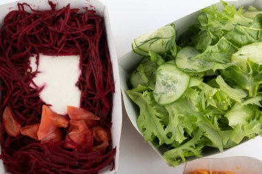 Karton tabaklarda yemeye hazır vejetaryenler ve çiğ gurmeler için farklı salatalar.