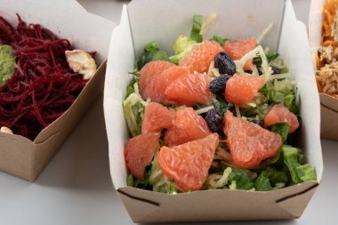 Karton tabaklarda yemeye hazır vejetaryenler ve çiğ gurmeler için farklı salatalar.