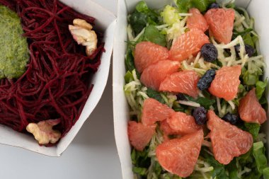 Karton tabaklarda yemeye hazır vejetaryenler ve çiğ gurmeler için farklı salatalar.