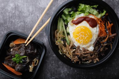  Kore yemeği, siyah mantar salatası. Üst görünüm kapalı. Koreansike çubukları ve bibimbap 'ın yanında.