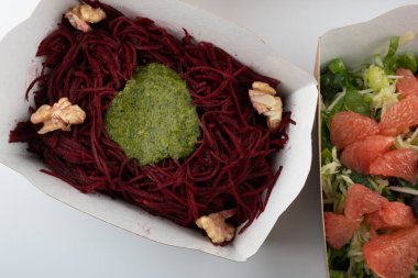 Karton tabaklarda yemeye hazır vejetaryenler ve çiğ gurmeler için farklı salatalar.