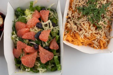 Karton tabaklarda yemeye hazır vejetaryenler ve çiğ gurmeler için farklı salatalar.