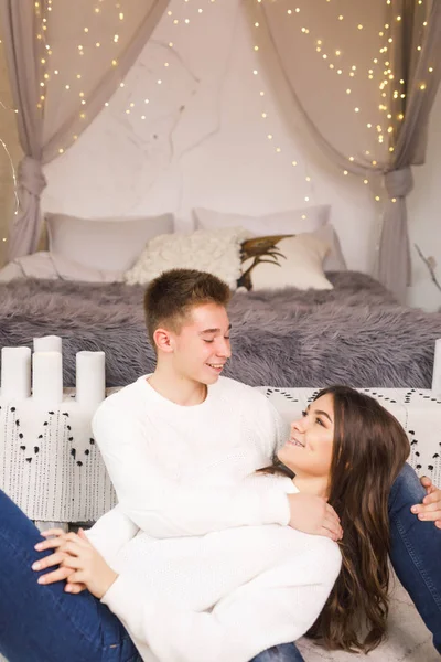 美しい白い部屋でベッドの上に座って笑顔若い美しいカップル — ストック写真