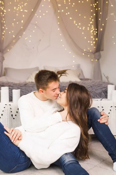 年轻漂亮的夫妇坐在一张漂亮的白色房间的床上 面带微笑 — 图库照片