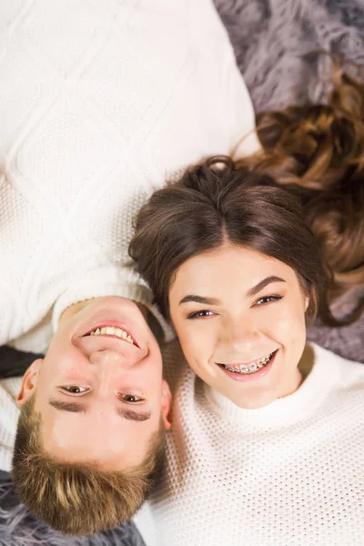 年轻漂亮的夫妇躺在一个漂亮的白色房间的地板上 面带微笑 — 图库照片