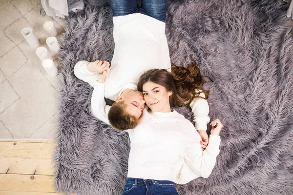若い美しいカップルが美しい白い部屋に床に横たわって笑顔 — ストック写真