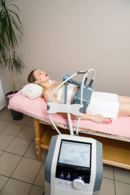 Doktor Güzellik Uzmanı hastanın karnı için ultrason prosedürü uyguluyor.