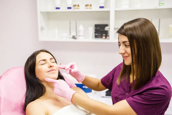 attractive female beautician doctor doing beauty injection for the patient