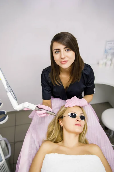 Morena Joven Esteticista Médico Haciendo Procedimiento Láser Paciente Con Gafas —  Fotos de Stock