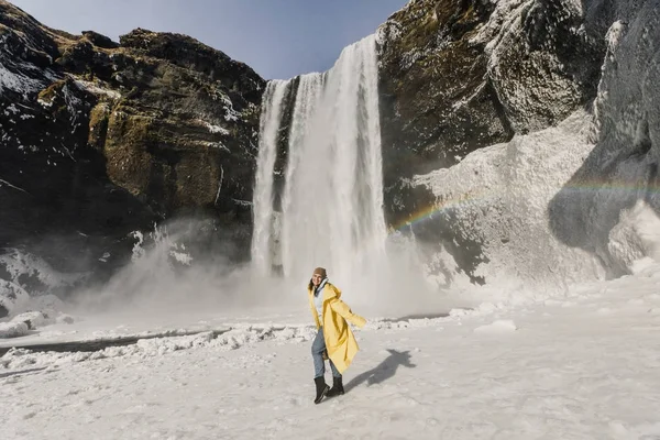 Gelukkig Vrouw Gele Jas Poseren Winter Waterval Met Regenboog Ijsland — Stockfoto